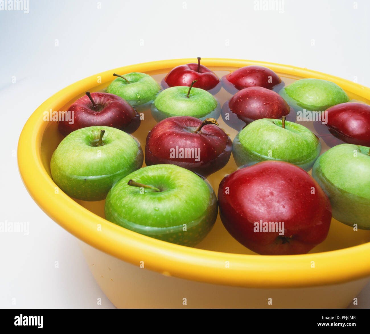 Bol de pommes (Malus) flottant dans l'eau Banque D'Images