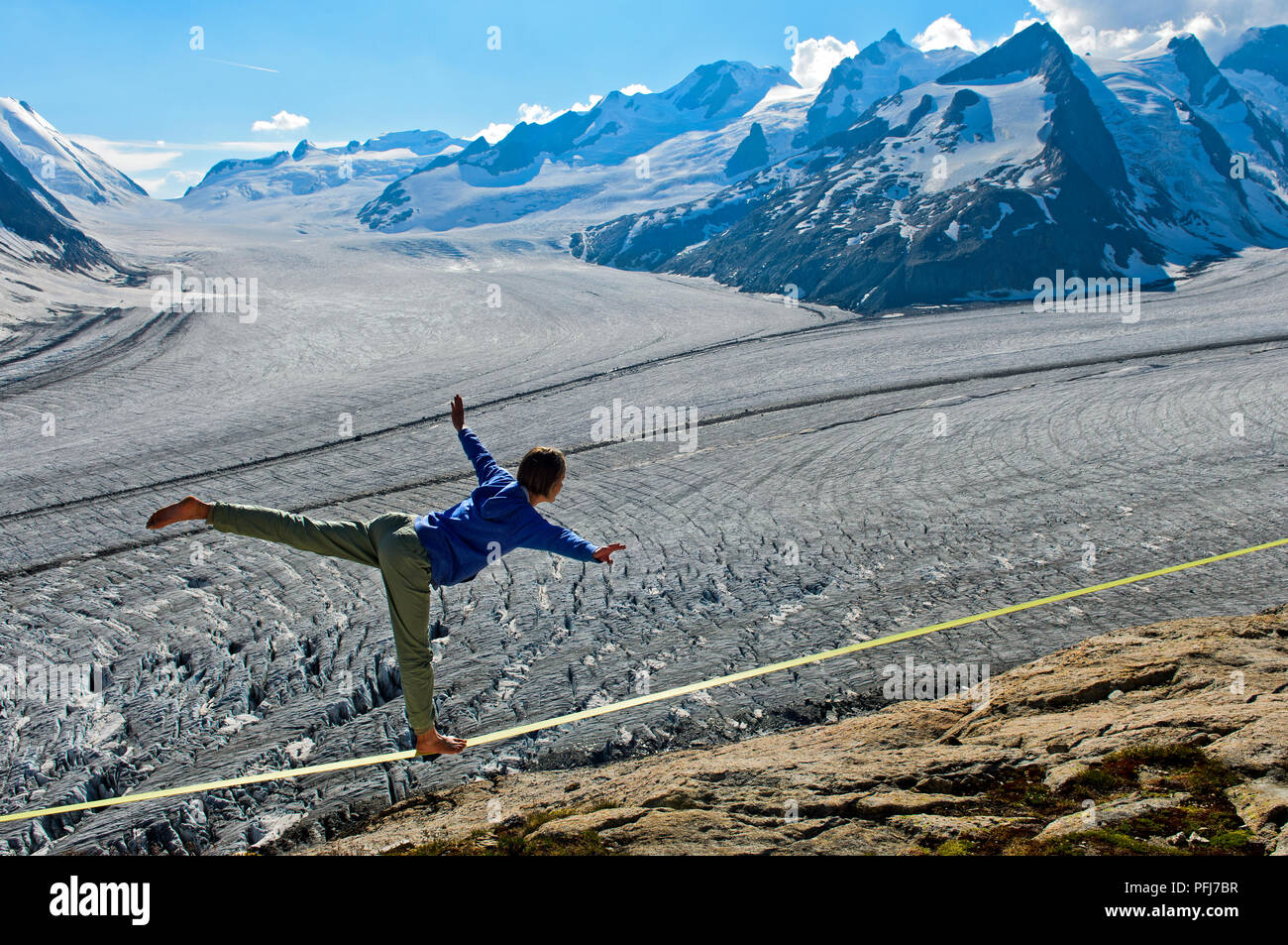 Jeune femme est en équilibre sur le slackline au refuge Konkordia sur le glacier glace à Konkordiaplatz, Alpes Bernoises, Valais, Suisse Banque D'Images