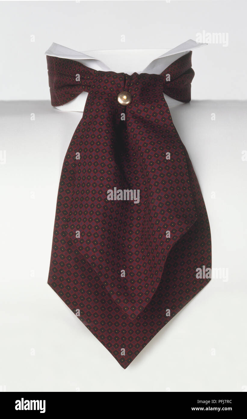 Foulard rouge-foncé, drapé autour de col montant comme cravate, fixés à l'aide de la broche d'or Banque D'Images
