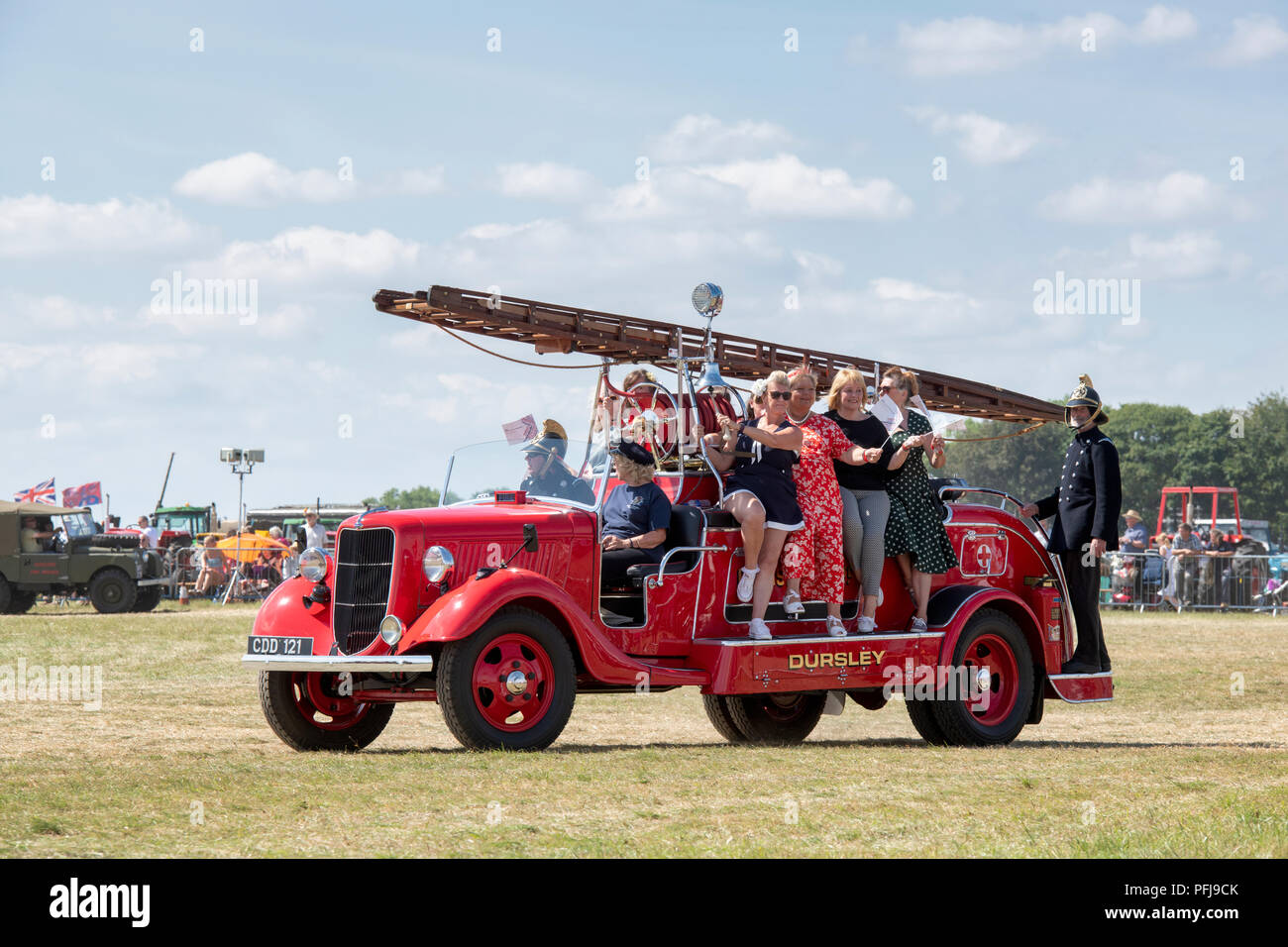 Vintage fire engine transportant un groupe de danseuses lors d'une foire à vapeur en Angleterre Banque D'Images