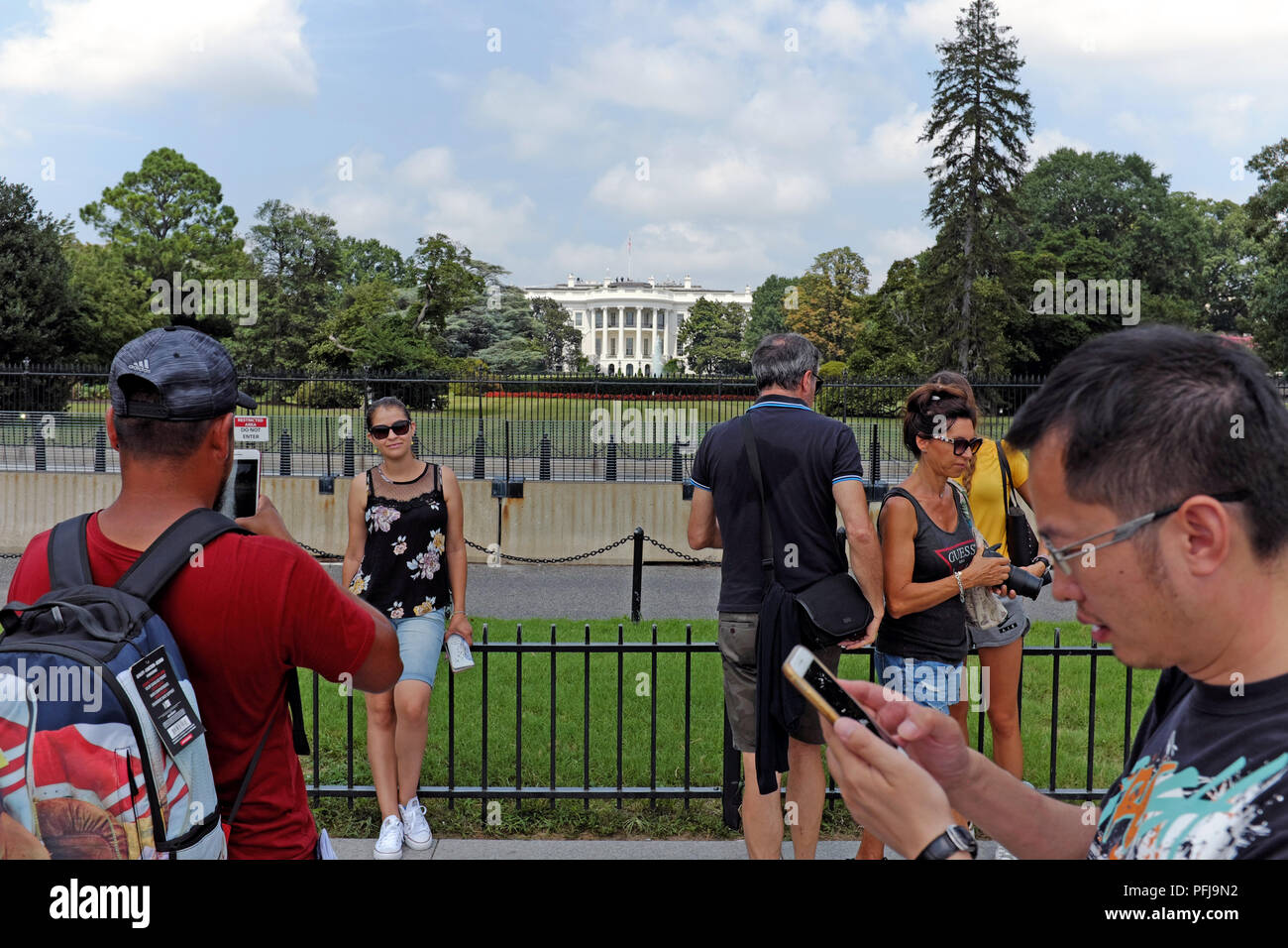 Les personnes qui prennent des photos avec les États-Unis Maison Blanche tout au fond avec les barrières séparant les visiteurs de l'attraction principale à Washington D.C. Banque D'Images