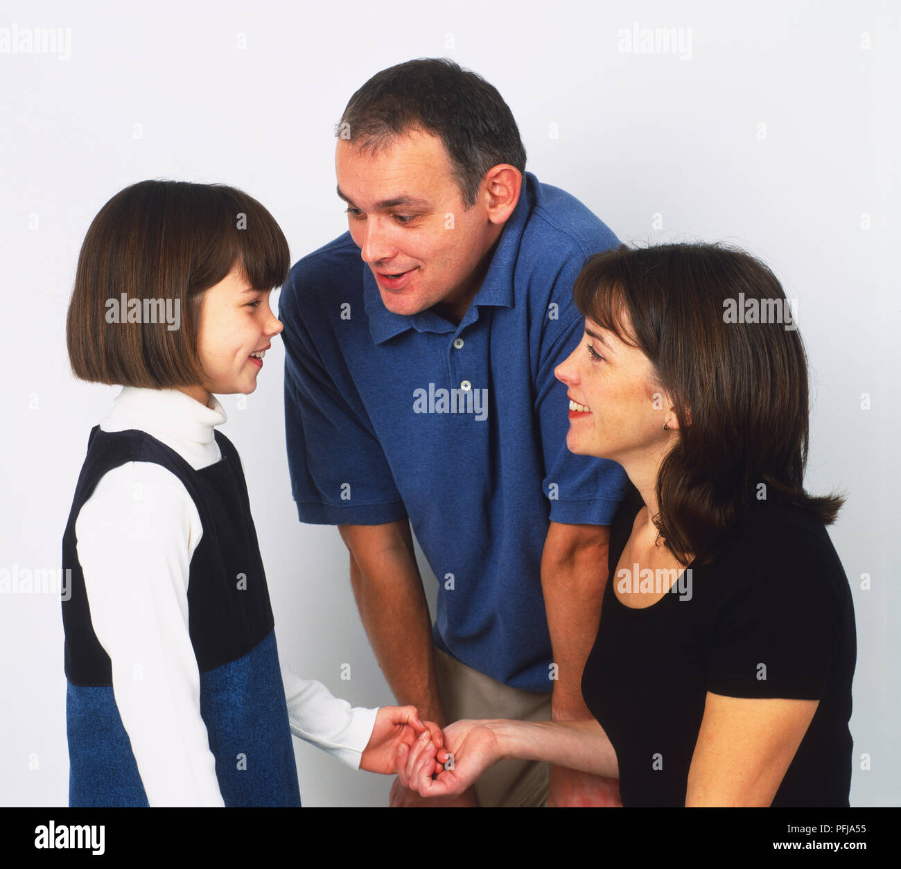 L'homme et la femme à parler à une fille, sourire, femme tenant la main de la jeune fille Banque D'Images