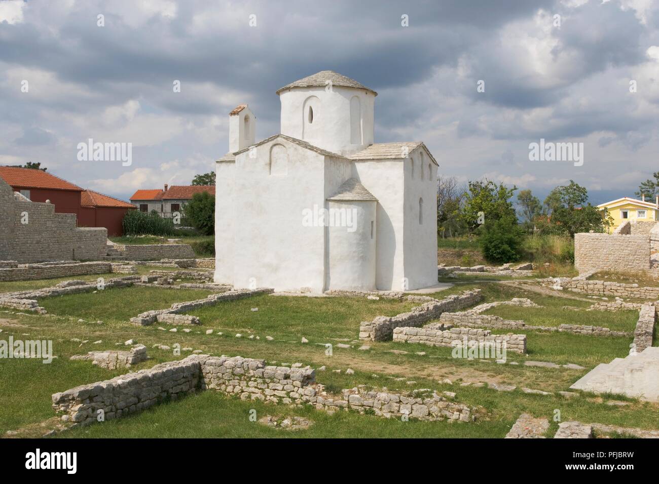 La Croatie, Nin, l'église de la Sainte Croix, extérieur blanc et les ruines des murs Banque D'Images