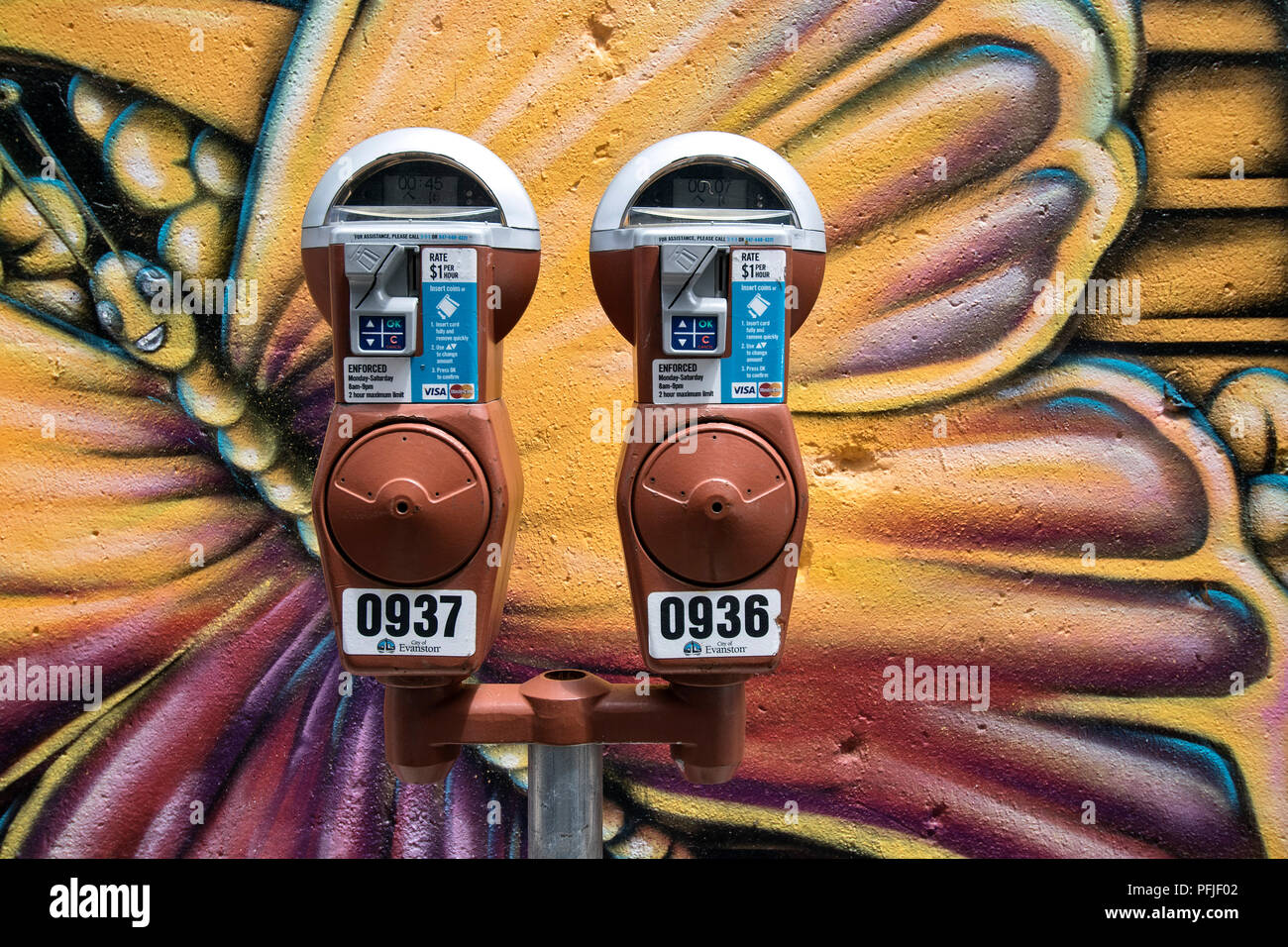 Un parcomètre devant un mur avec graffiti papillon à Evanston, Illinois, USA. Banque D'Images