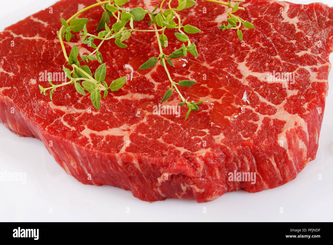 Close-up de marbre sur le faux filet de boeuf au thym steak isolé sur fond blanc, vue d'en haut Banque D'Images