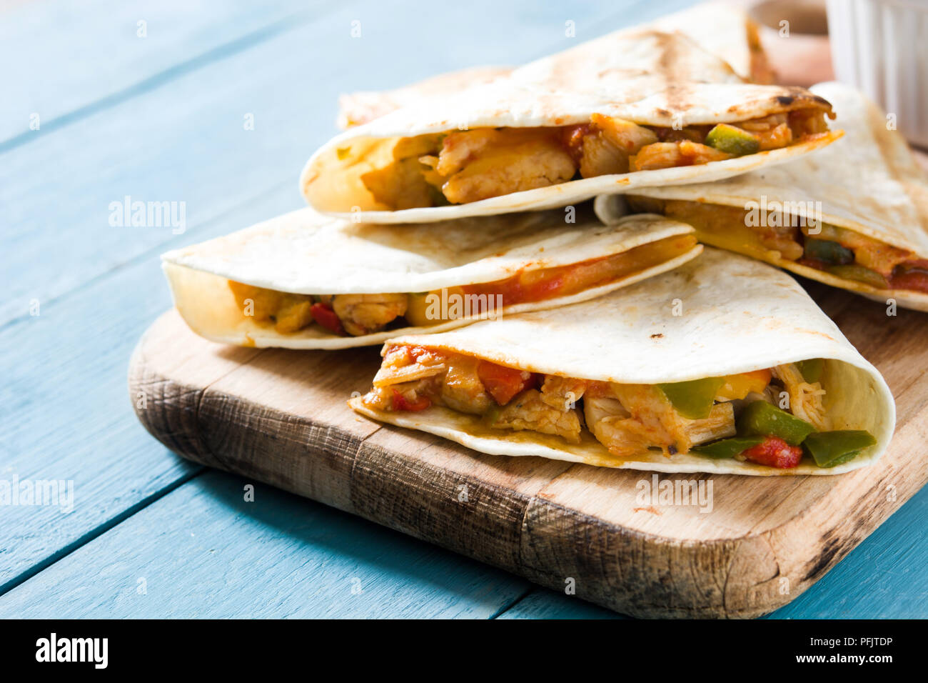 Mexican quesadilla au poulet, fromage et poivrons sur table en bois bleu. Banque D'Images