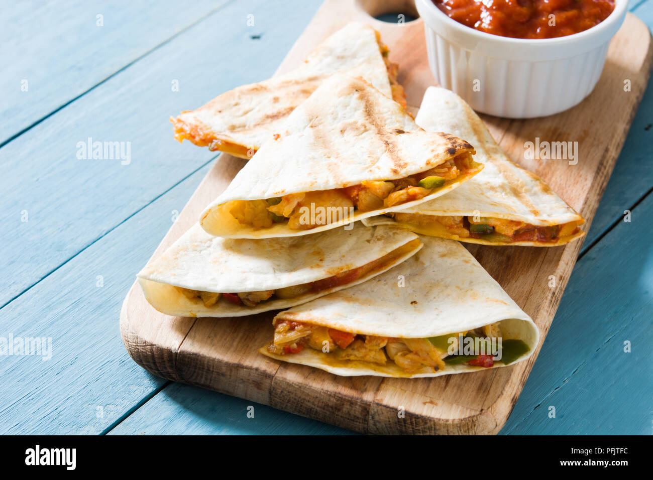 Mexican quesadilla au poulet, fromage et poivrons sur table en bois bleu. Banque D'Images