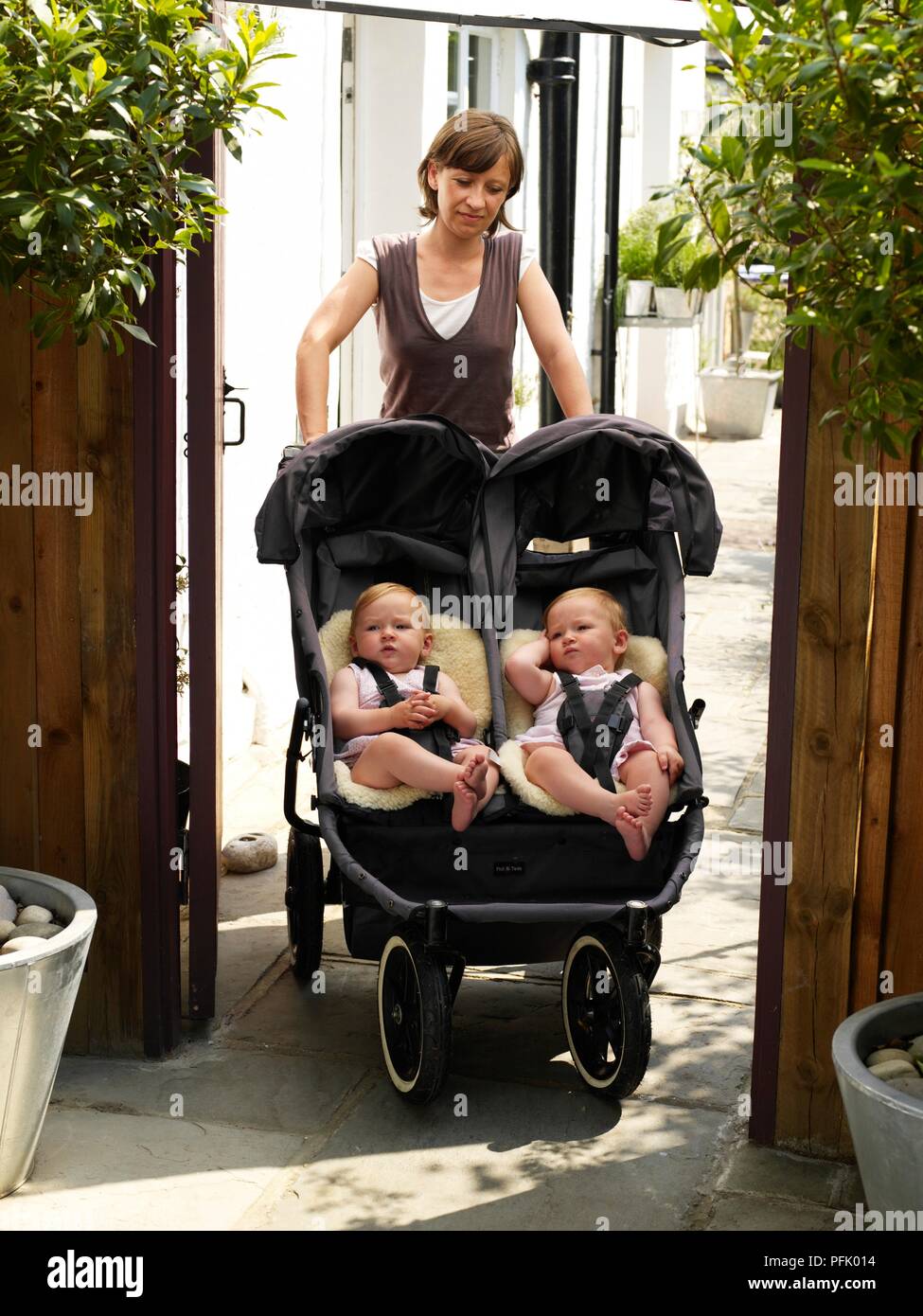 Lits bébé filles en chambre double poussette, mère debout derrière eux  Photo Stock - Alamy