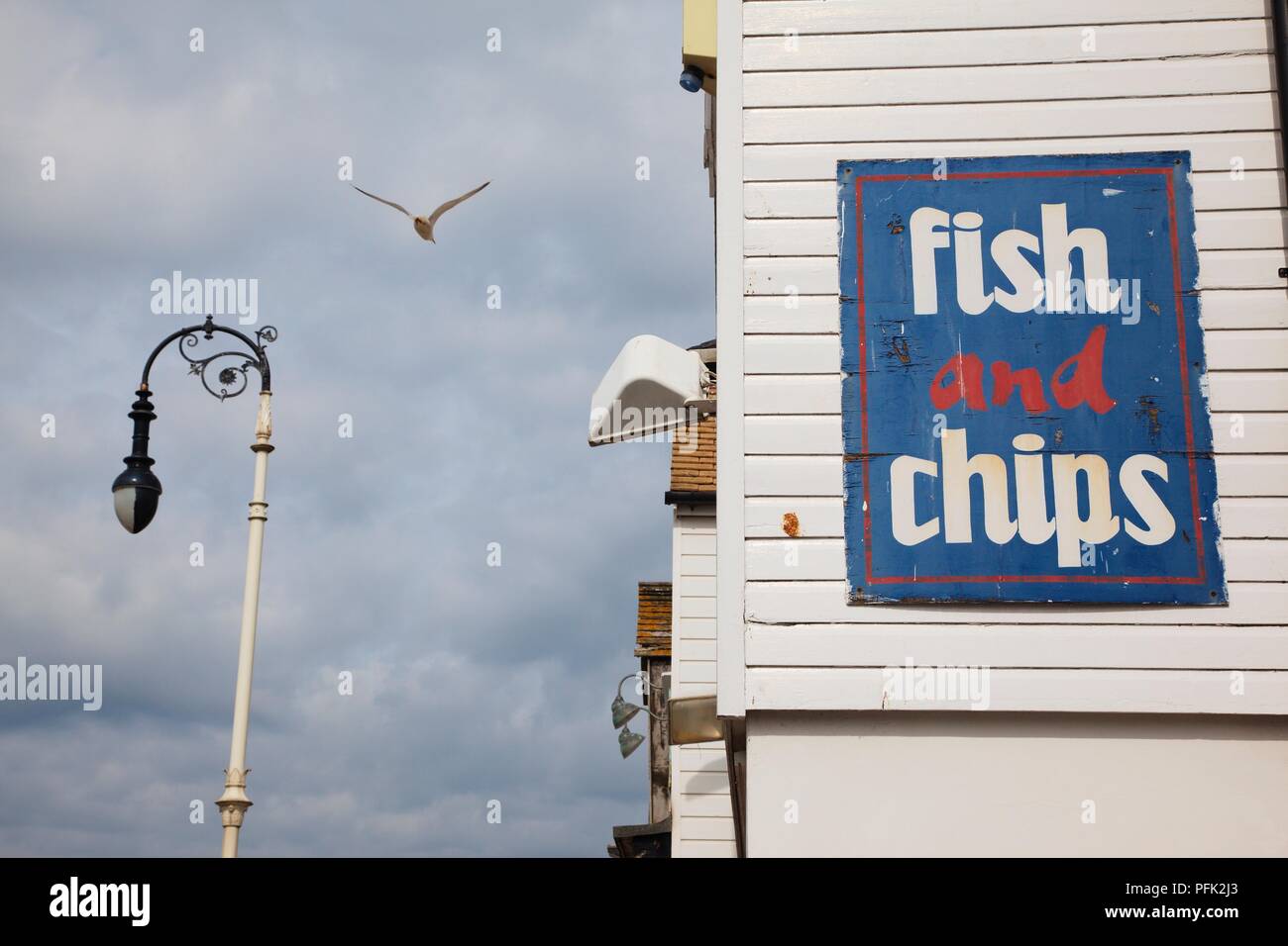 La Grande-Bretagne, l'Angleterre, Hastings, mouette volant au-dessus de la rue victorien à l'extérieur de la lampe poisson et chip shop Banque D'Images