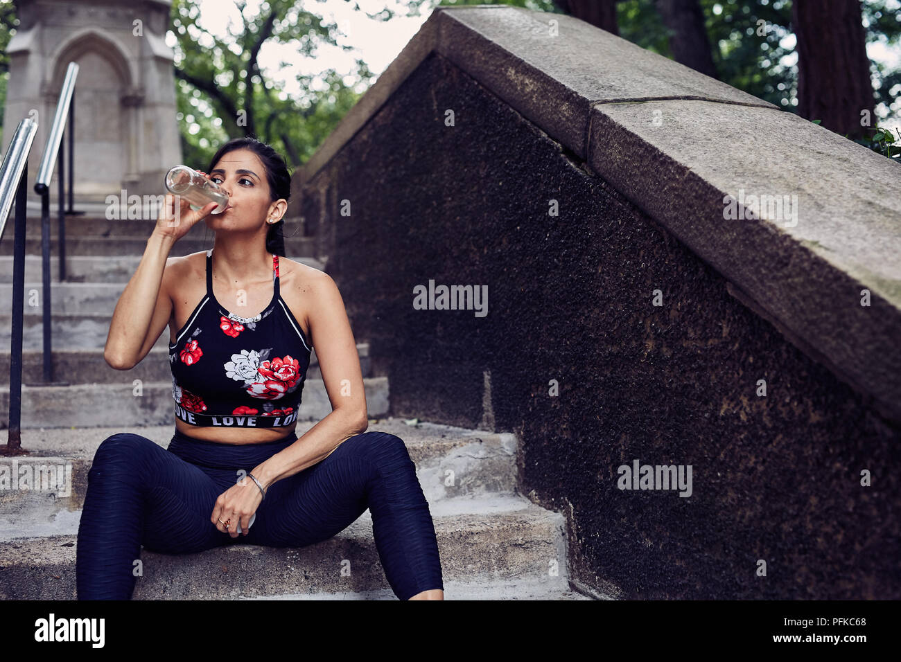 Latina Woman boit de l'eau après l'entraînement Banque D'Images