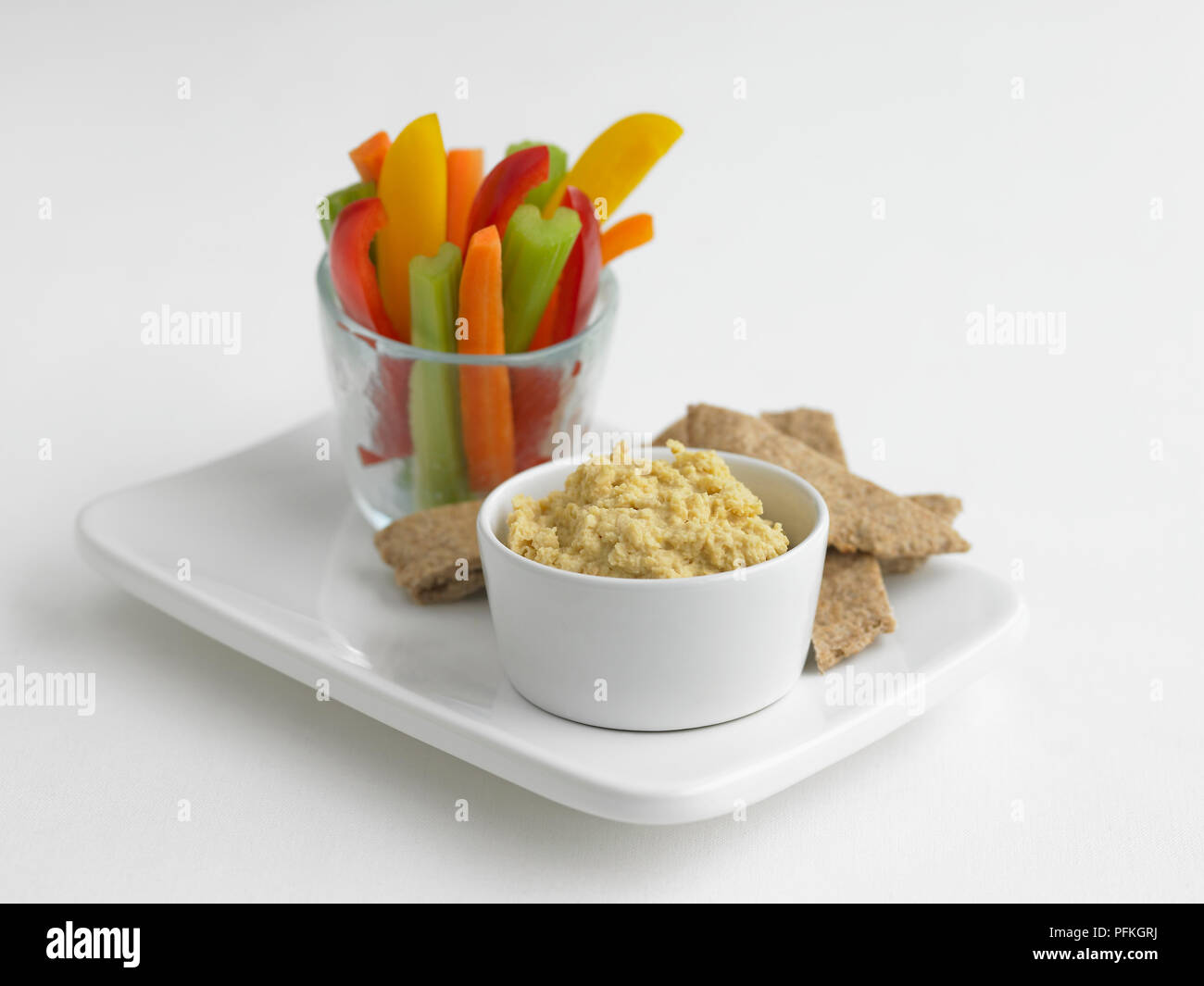Bol de l'hoummos, bâtonnets de poivrons, carotte et céleri en verre, avec du pain pitta on tray Banque D'Images