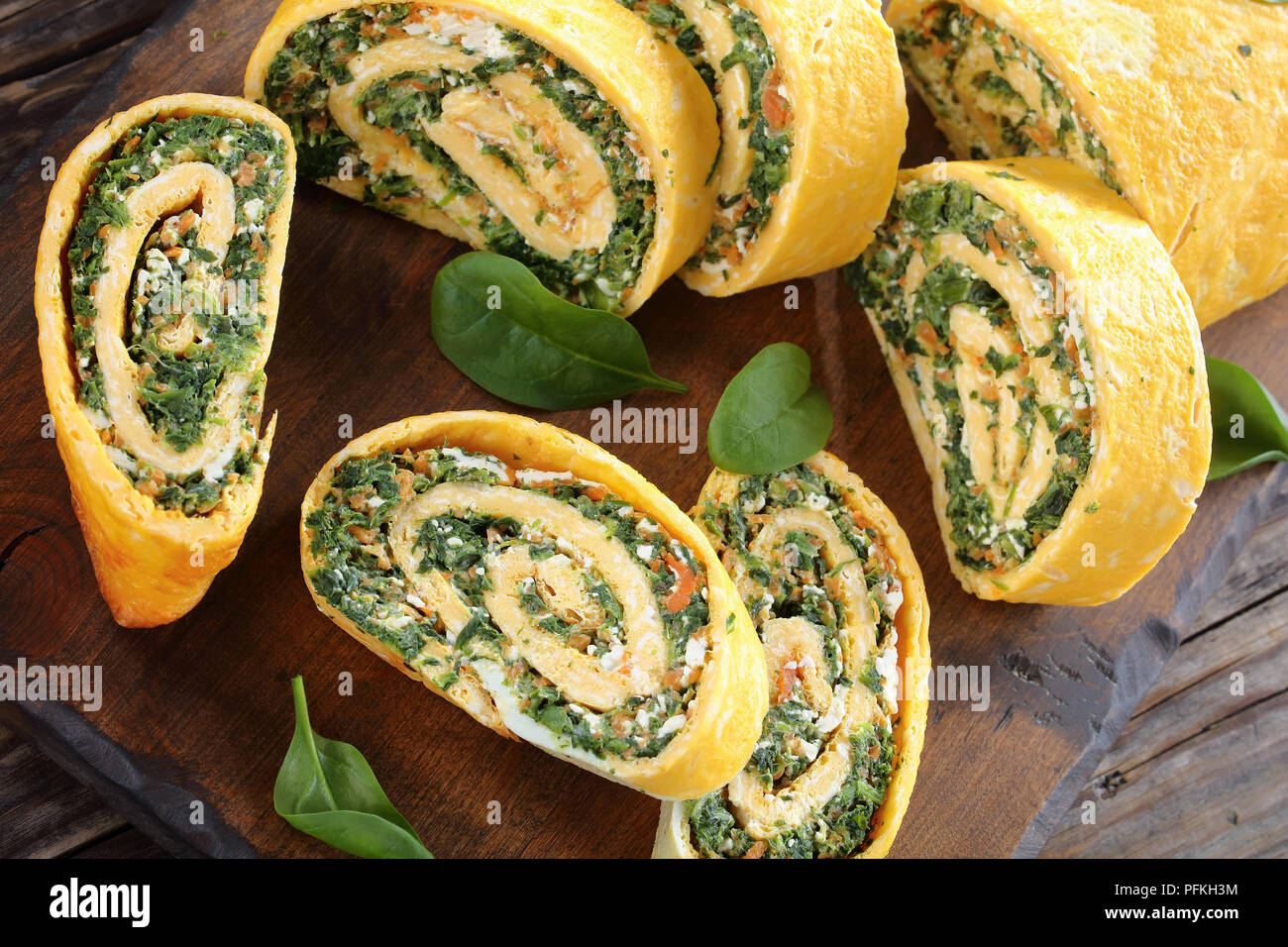 Roulade oeufs servis sous la forme d'un rouleau fait à partir d'un morceau de salé, éponge, étaler avec un remplissage doux d'épinards, la feta et les carottes et laminé Banque D'Images
