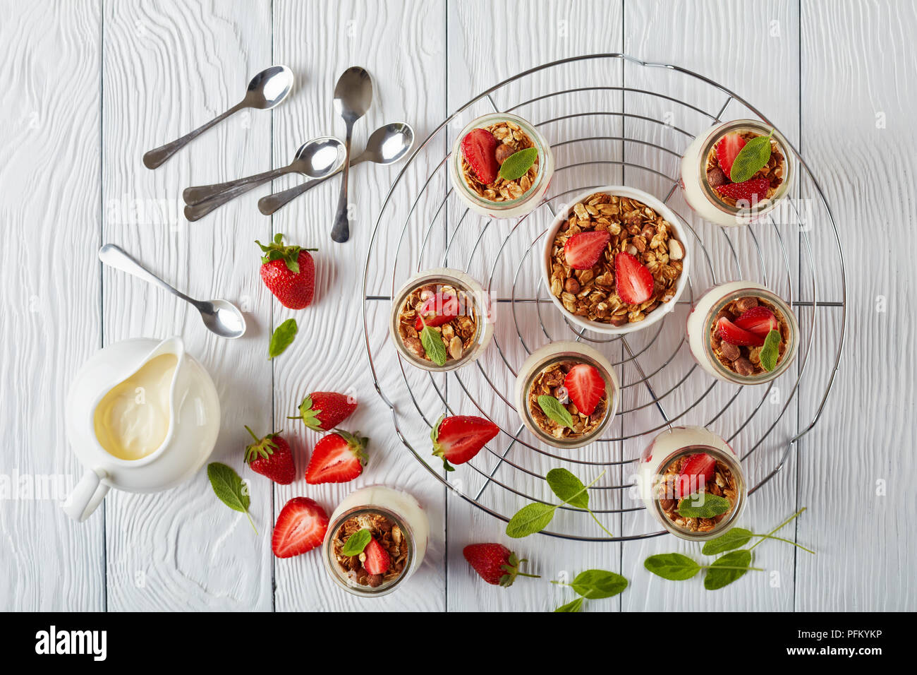 Délicieux muesli maison posée avec du yaourt frais et de fraise mûre, en partie en pots de verre sur métal, vue horizontale à partir de ci-dessus, Banque D'Images