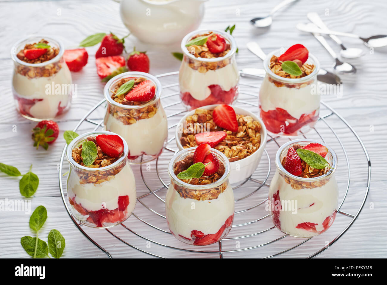Délicieux muesli maison posée avec du yaourt frais et de fraise mûre, en partie en pots de verre sur métal, vue horizontale à partir de ci-dessus, close-up Banque D'Images