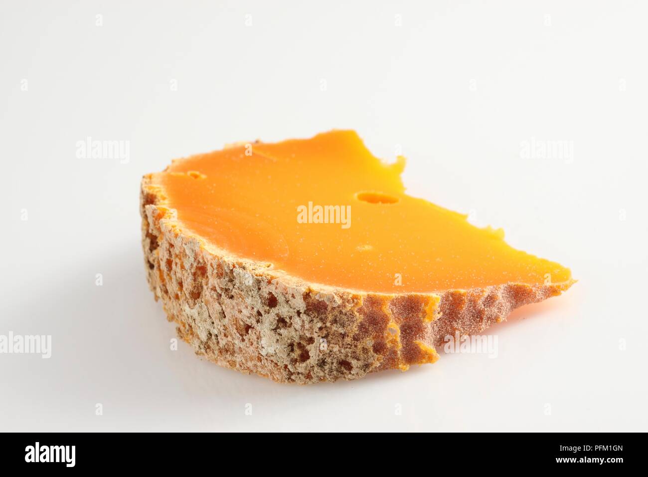 Mimolette française tranche de fromage au lait de vache à croûte texturée Banque D'Images