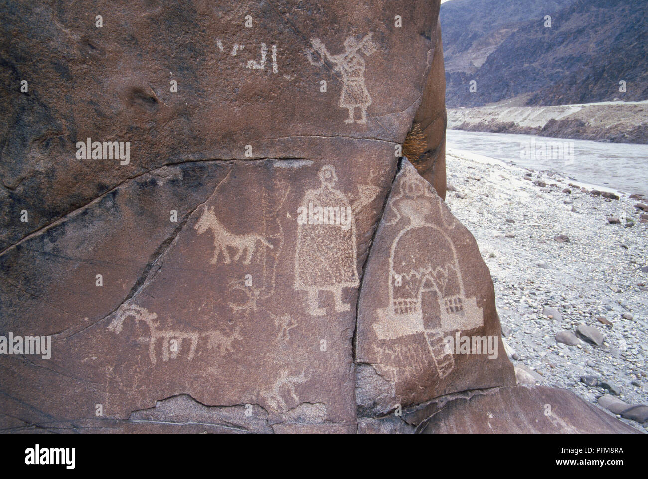 Images d'animaux et de figures humaines sont parmi les 30 000 sculptures sur roc près du village de Chilas dans les montagnes du Karakoram au nord du Pakistan. L'Indus est également visible par les rochers. Banque D'Images