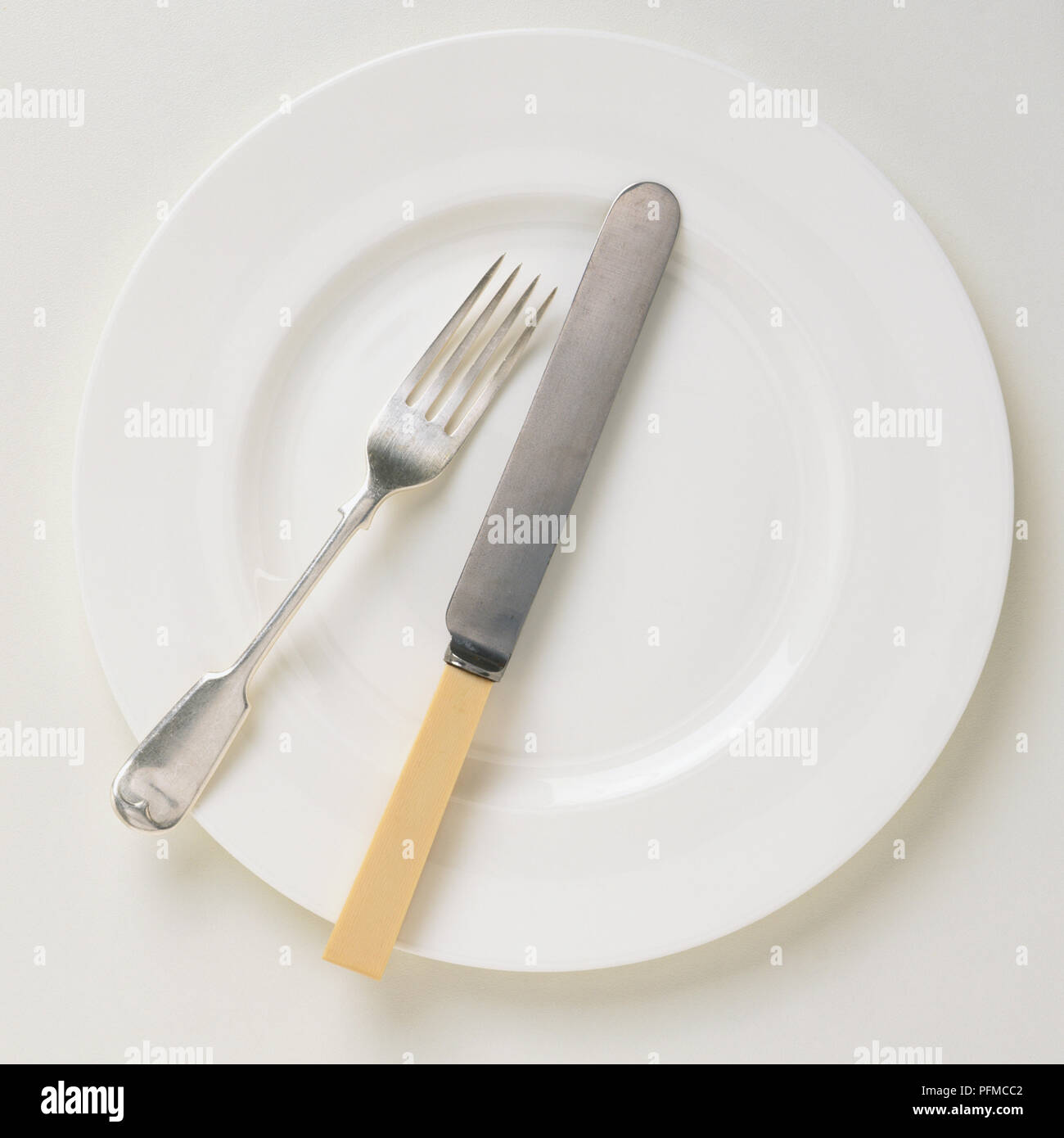 Le couteau et la fourchette sur une assiette blanche, vue d'en haut Banque D'Images