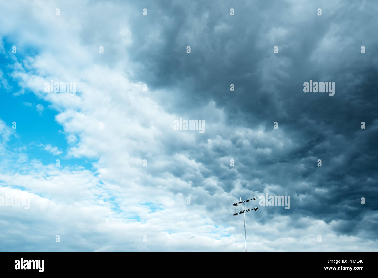 Sinistre sombre nuages orageux sur réflecteur stade feux sont apportant la pluie et le froid Banque D'Images