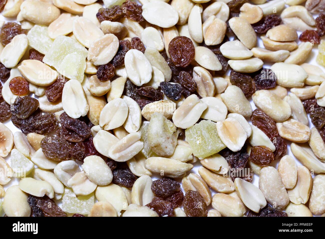 On a white background isolés se trouve un mélange de noix et de fruits. Le mélange est constitué d'arachides, les fruits confits, les raisins et les bananes séchées. Banque D'Images