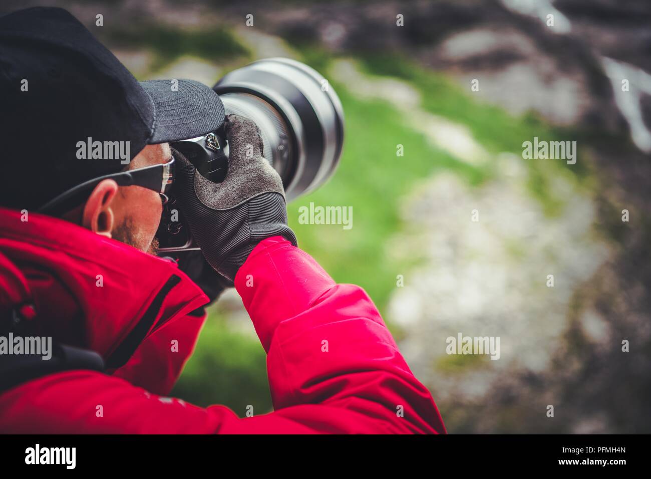 Une photographe au travail. Les hommes de race blanche avec un appareil photo numérique et téléobjectif. Photo gros plan. Banque D'Images