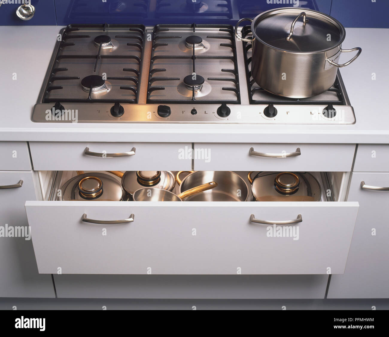 Les casseroles et poêles stockées dans des tiroirs de Cuisine partiellement ouverte en dessous de cuisson, augmentation de la vue. Banque D'Images