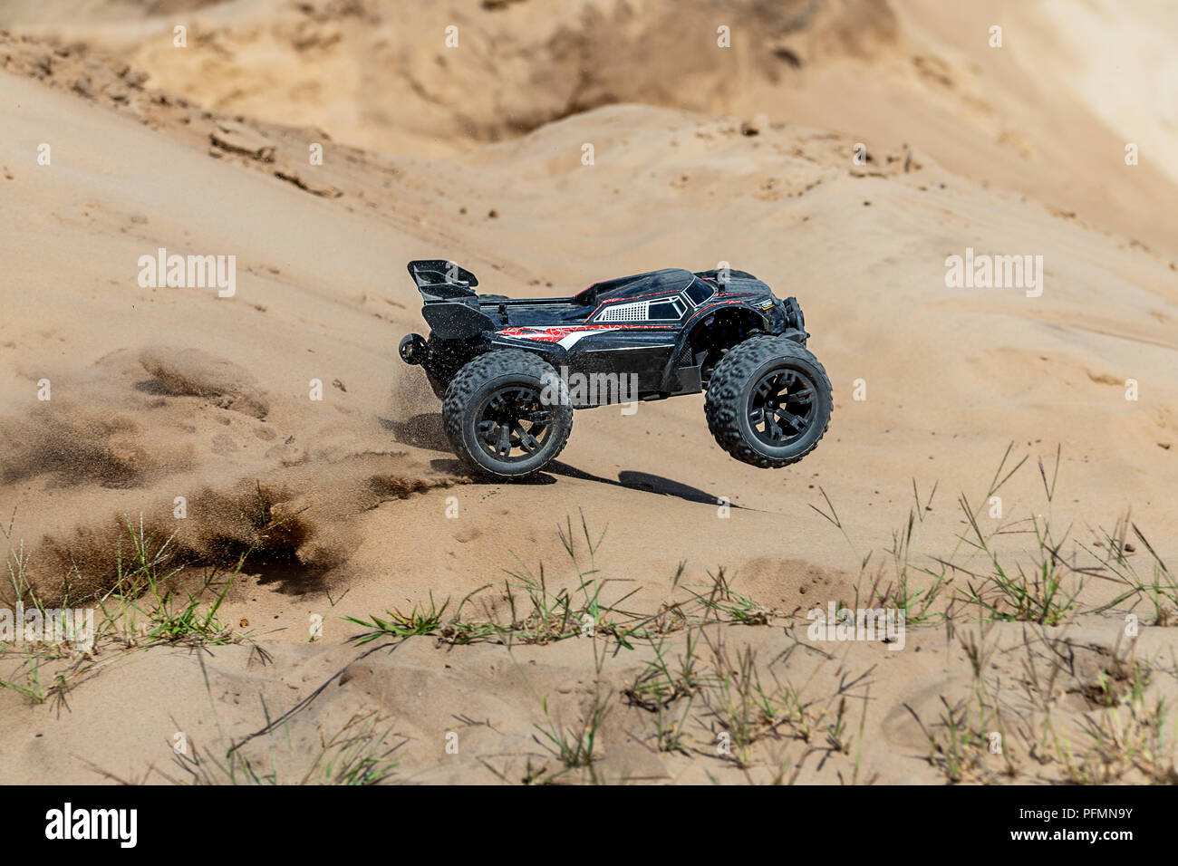 Grosse voiture buggy radio-commandé conduite rapide et glisser sur le sable. RC toy se déplaçant rapidement sur la surface du terrain avec la poussière et la boue à l'extérieur. Enfants hobby concept Banque D'Images