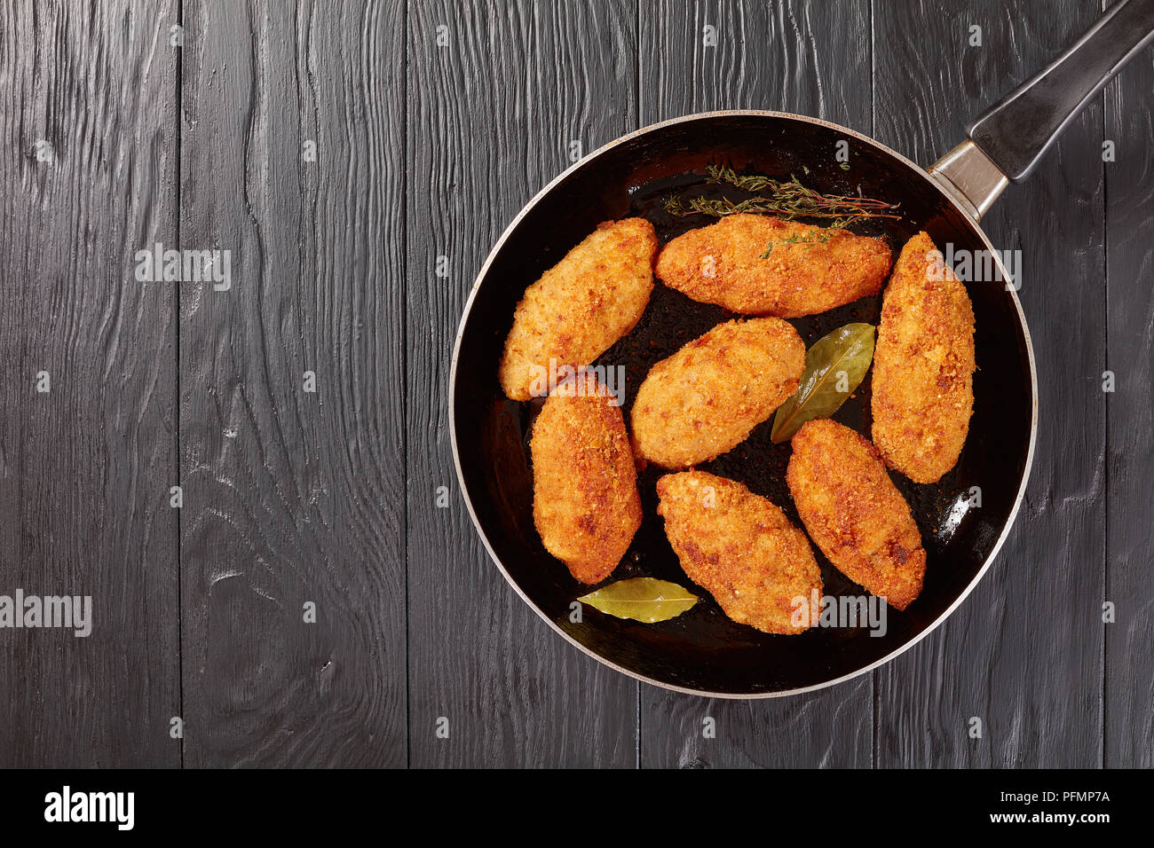 Croquettes de viande frits au fromage fondu garniture sur une poêle sur une table en bois, vue du dessus Banque D'Images