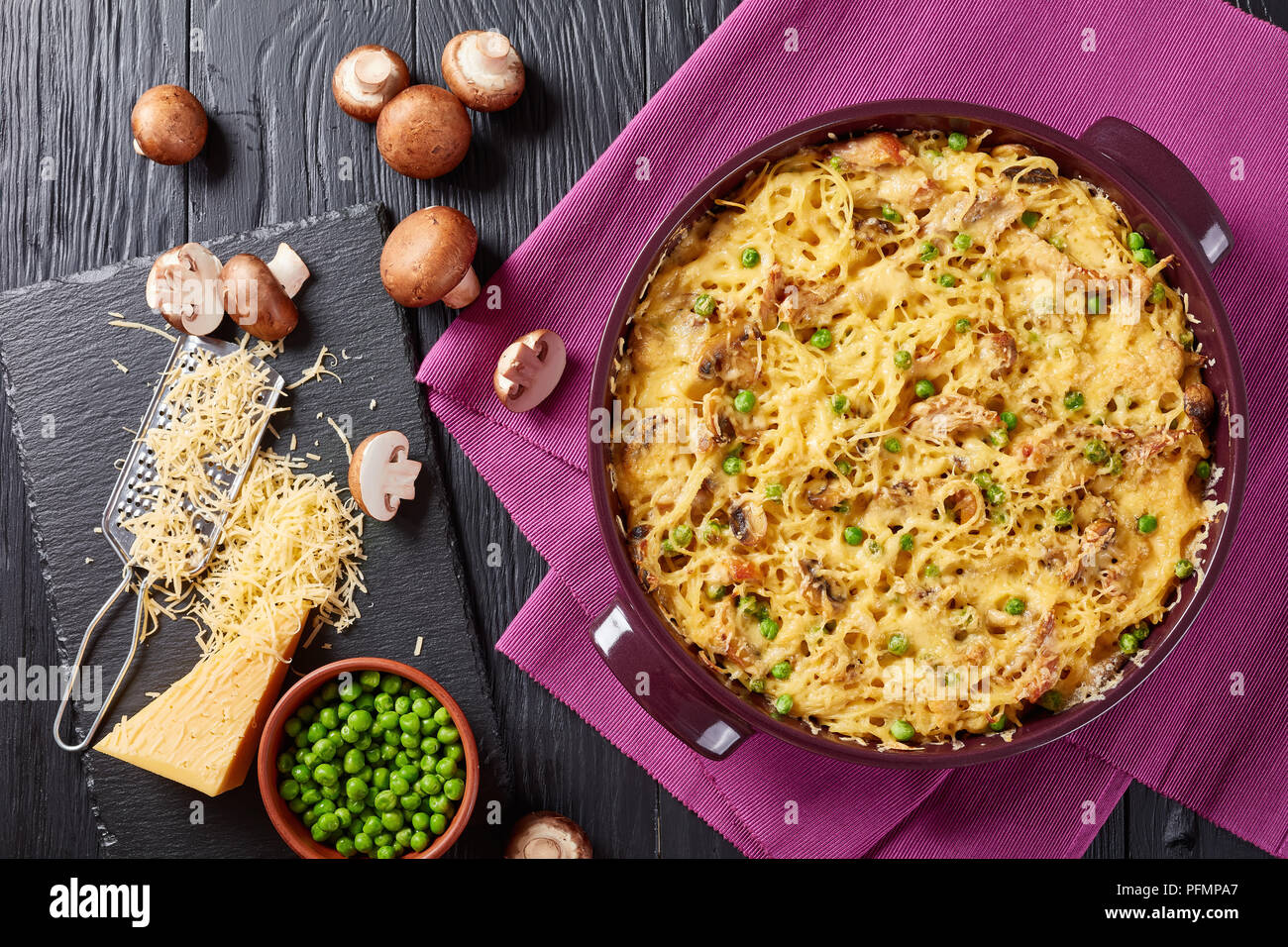 - Spaghetti Tetrazzini à la Turquie, la viande, le fromage râpé, les pois verts, les champignons dans une cocotte allant au four avec des ingrédients à l'arrière-plan, une cuisine américaine, Banque D'Images
