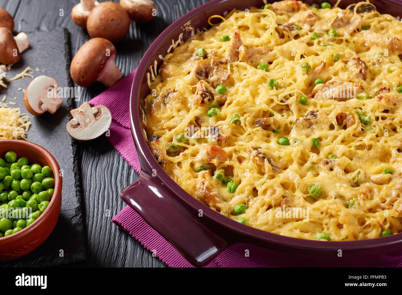- Tetrazzini à la crème, pâtes, viande de poulet, fromage râpé, petits pois, champignons en cocotte dans un plat allant au four avec des ingrédients à l'arrière-plan, classic Banque D'Images