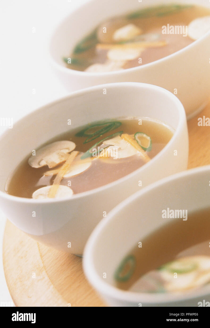 Bols de soupe claire, contenant les champignons tranchés et bandes de gingembre Banque D'Images