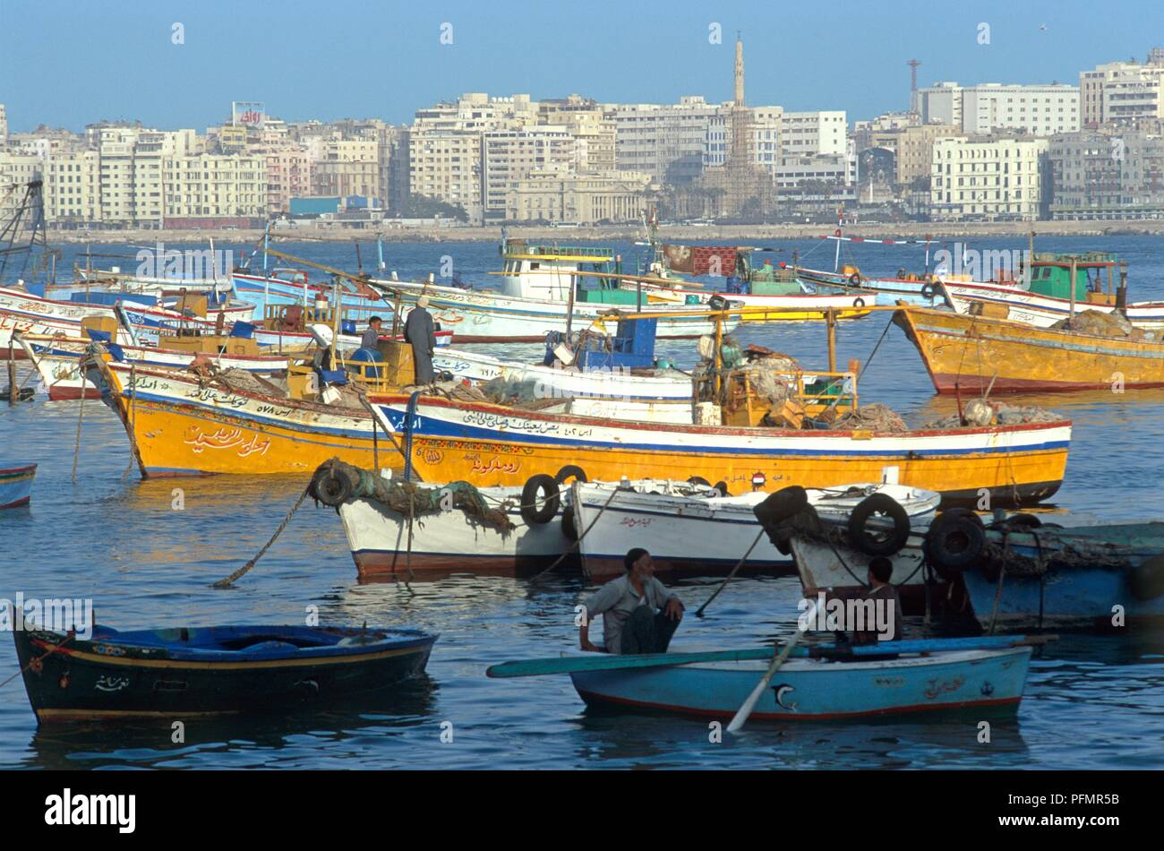 Egypte, Alexandrie, grands et petits bateaux de pêche dans le port, avec des hôtels modernes donnant sur San Stefano beach Banque D'Images