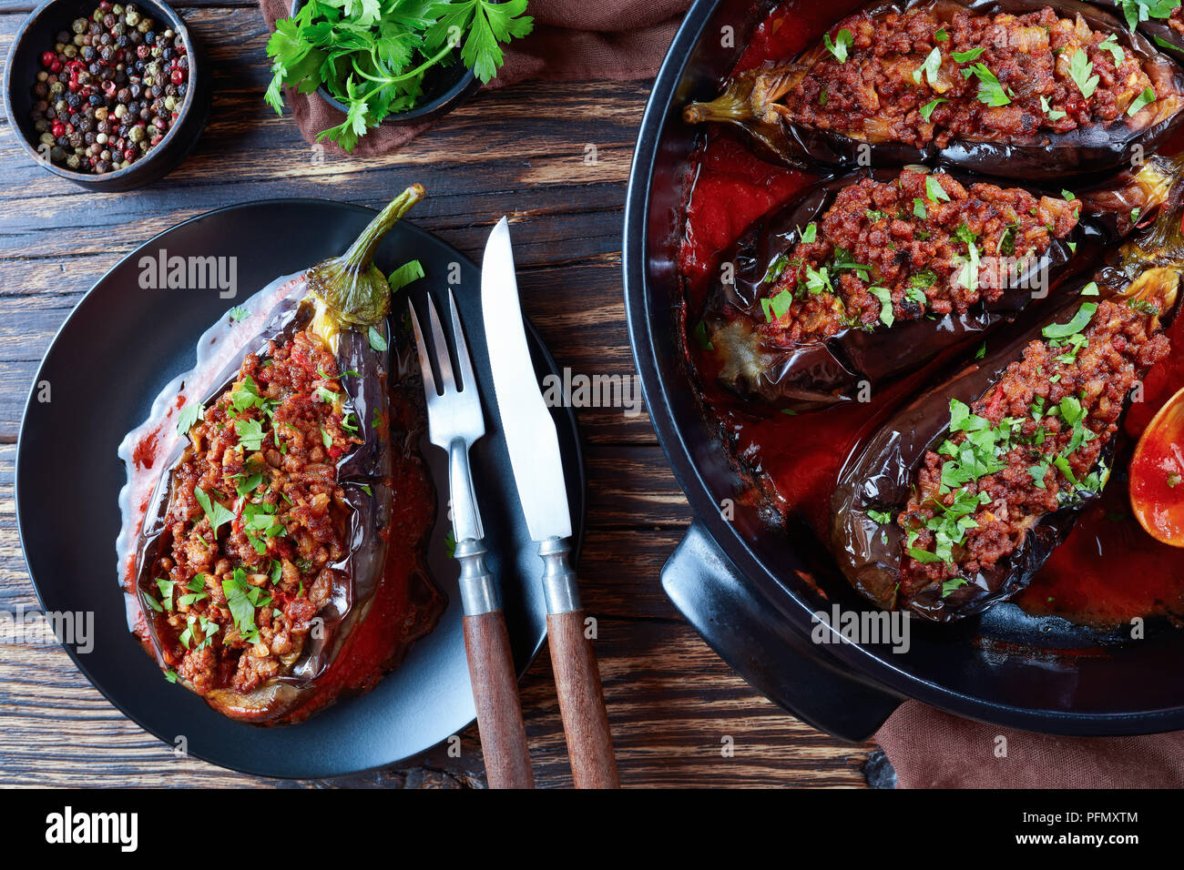 - Karniyarik, Aubergines Aubergines farcies avec du boeuf haché et de légumes cuits au four avec sauce tomate servi sur une plaque avec fourchette et couteau, Turkish cuis Banque D'Images