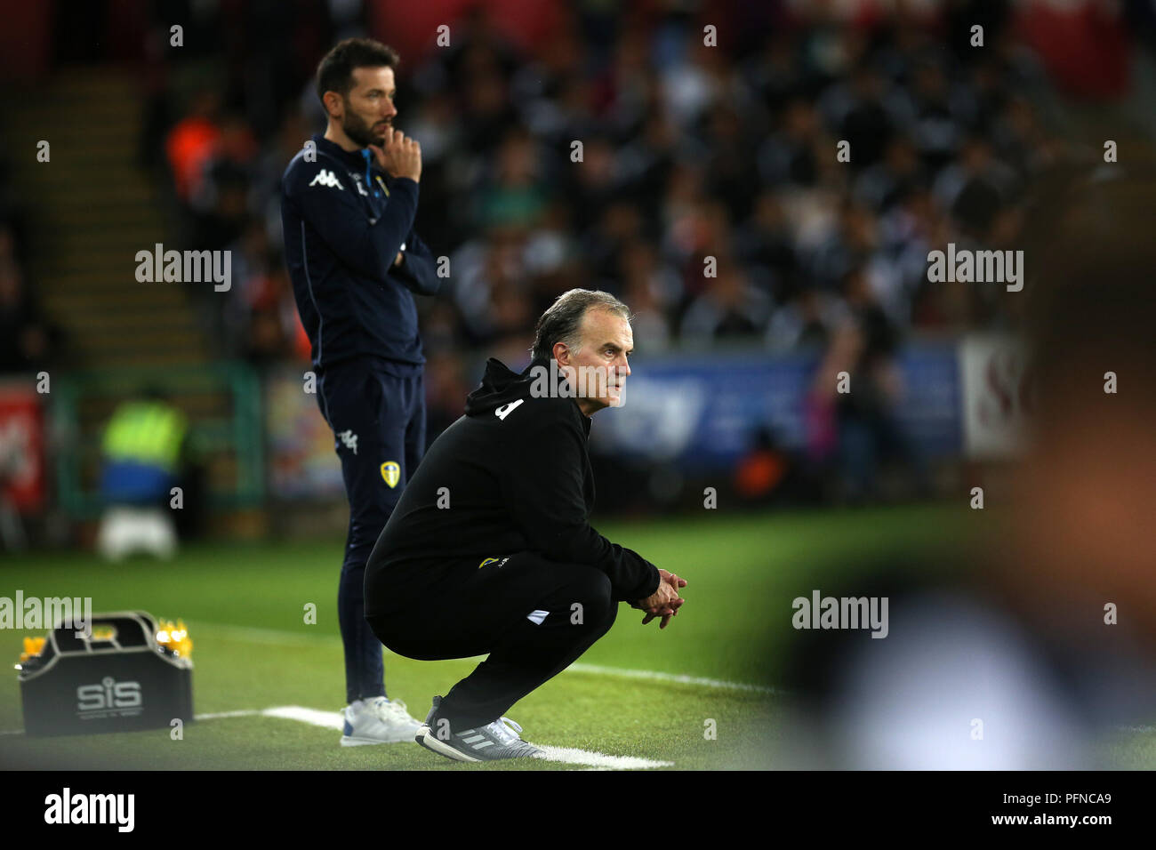 Swansea, Pays de Galles, Royaume-Uni. Août 21, 2018. Leeds Utd manager Marcelo Bielsa s'accroupit vers le bas en bas de la ligne de touche pendant qu'il observe son équipe jouer. Match de championnat Skybet EFL, Swansea City v Leeds Utd au Liberty Stadium de Swansea, Pays de Galles du Sud le mardi 21 août 2018. Cette image ne peut être utilisé qu'à des fins rédactionnelles. Usage éditorial uniquement, licence requise pour un usage commercial. Aucune utilisation de pari, de jeux ou d'un seul club/ligue/dvd publications. Photos par Andrew Andrew/Verger Verger la photographie de sport/Alamy live news Banque D'Images