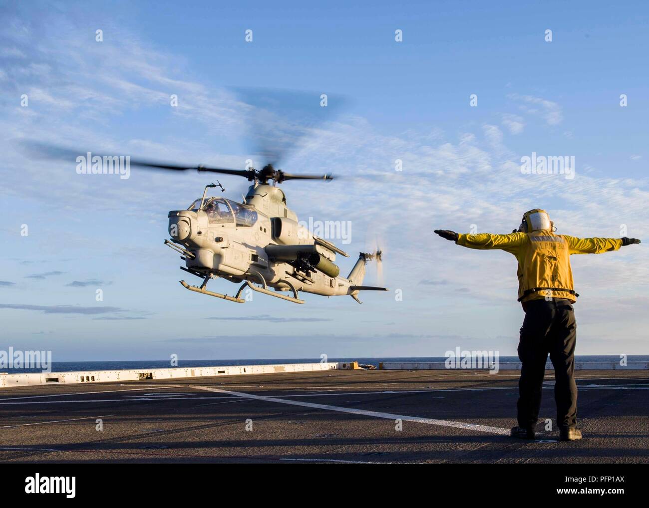 180725-N-PH222-0042 de l'OCÉAN PACIFIQUE (25 juillet 2018) l'Aviation maître de Manœuvre (manipulation), 3ème classe Frederick Medina de Delano, en Californie, est le signe d'un AH - 1Z hélicoptère Viper, affectés à un détachement d'hélicoptère d'attaque légère Marine Marine de rotors basculants moyen (VMM) de l'Escadron 166, comme il se prépare à atterrir sur le pont de San Antonio-classe de transport amphibie USS dock Anchorage (LPD 23) lors d'un déploiement prévu d'Essex Groupe amphibie (ARG) et 13e Marine Expeditionary Unit (MEU). L'Essex ARG/MEU team est une force solide et souple et évolutive équipée pour répondre à toute Banque D'Images