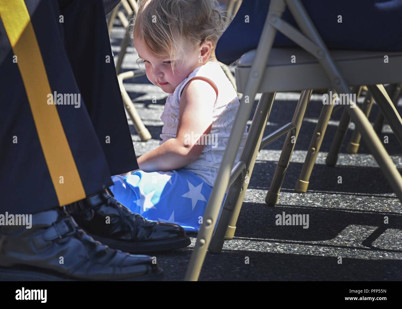 Deux ans, Jessica Herbert joue aux pieds de N.J. Le personnel de la Police d'État Le Sgt. Jaclyn B. Jiras au cours de la parade annuelle de la cérémonie des couronnes 24 Mai, 2018 at Joint Base McGuire-Dix-Lakehurst, New Jersey. Environ 50 policiers de l'état de N. L'ensemble de l'État ont assisté à la cérémonie tenue en l'honneur du Jour du Souvenir. Banque D'Images