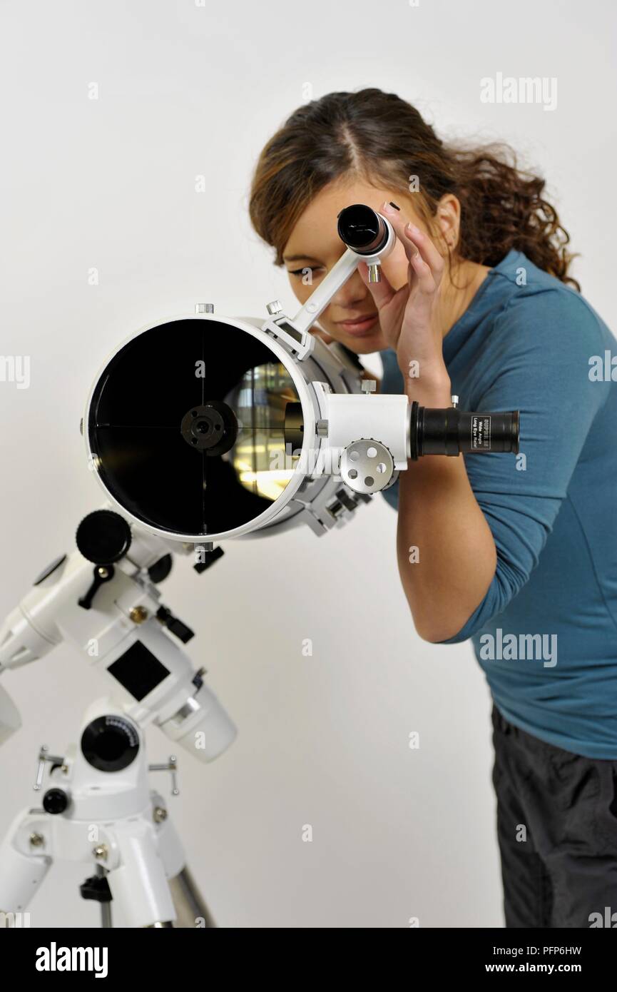 Femme regardant par l'oculaire de chercheur Banque D'Images