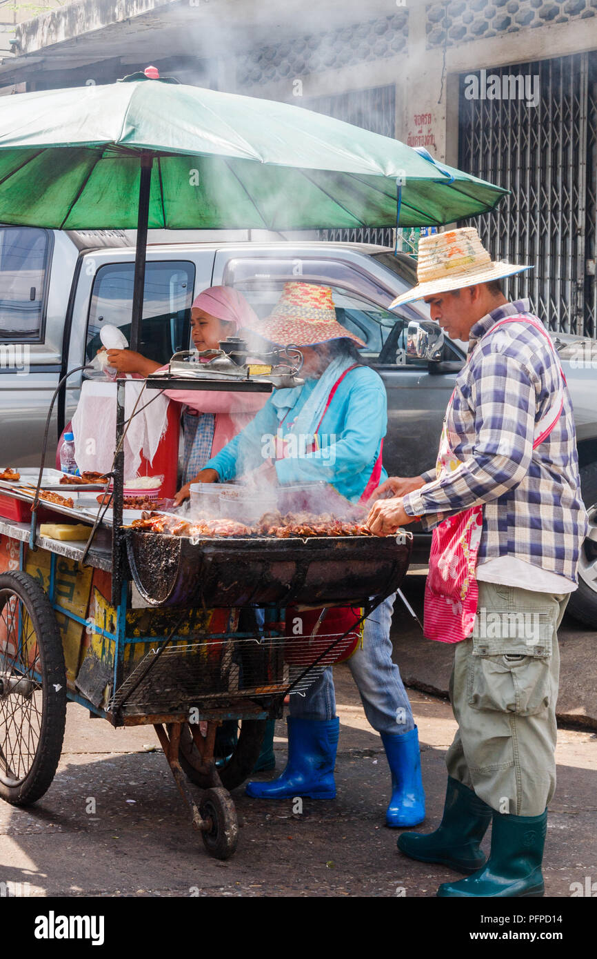 Vendeurs de rue barbecueing poulet pour la vente, Bangkok, Thaïlande Banque D'Images