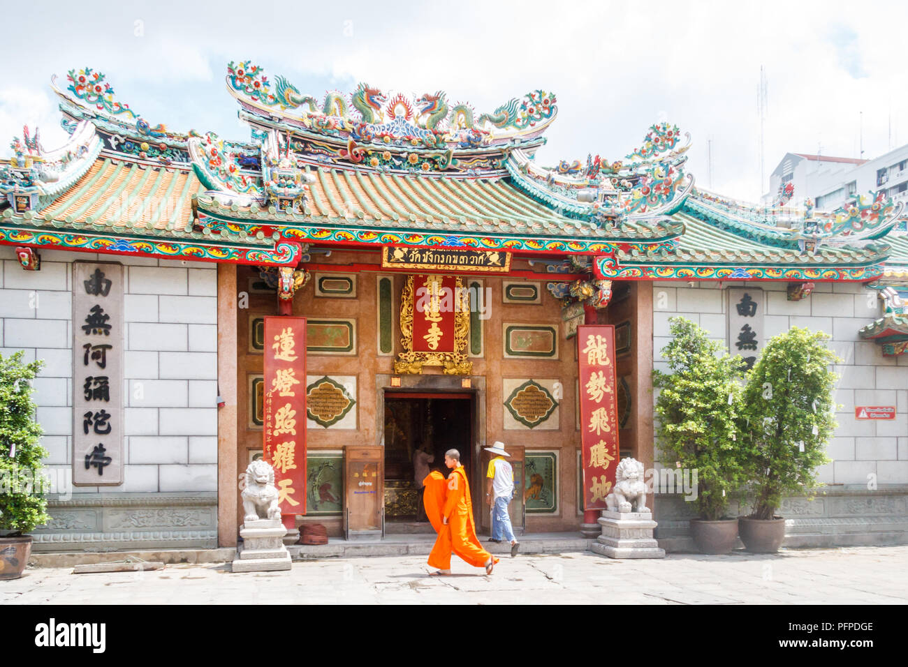 Bangkok, Thaïlande - 27 septembre 2016 : Un moine en robe orange passe devant un temple chinois. Il y a plusieurs temples de style chinois. Banque D'Images