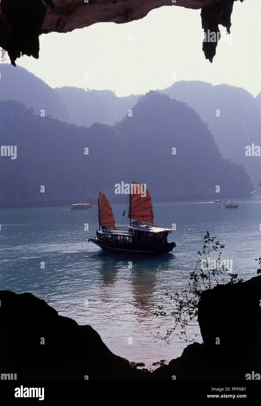 Vietnam, la baie d'Halong, grottes de tambour, junk ship in sea, encadrée par de grandes lignes entrée Banque D'Images