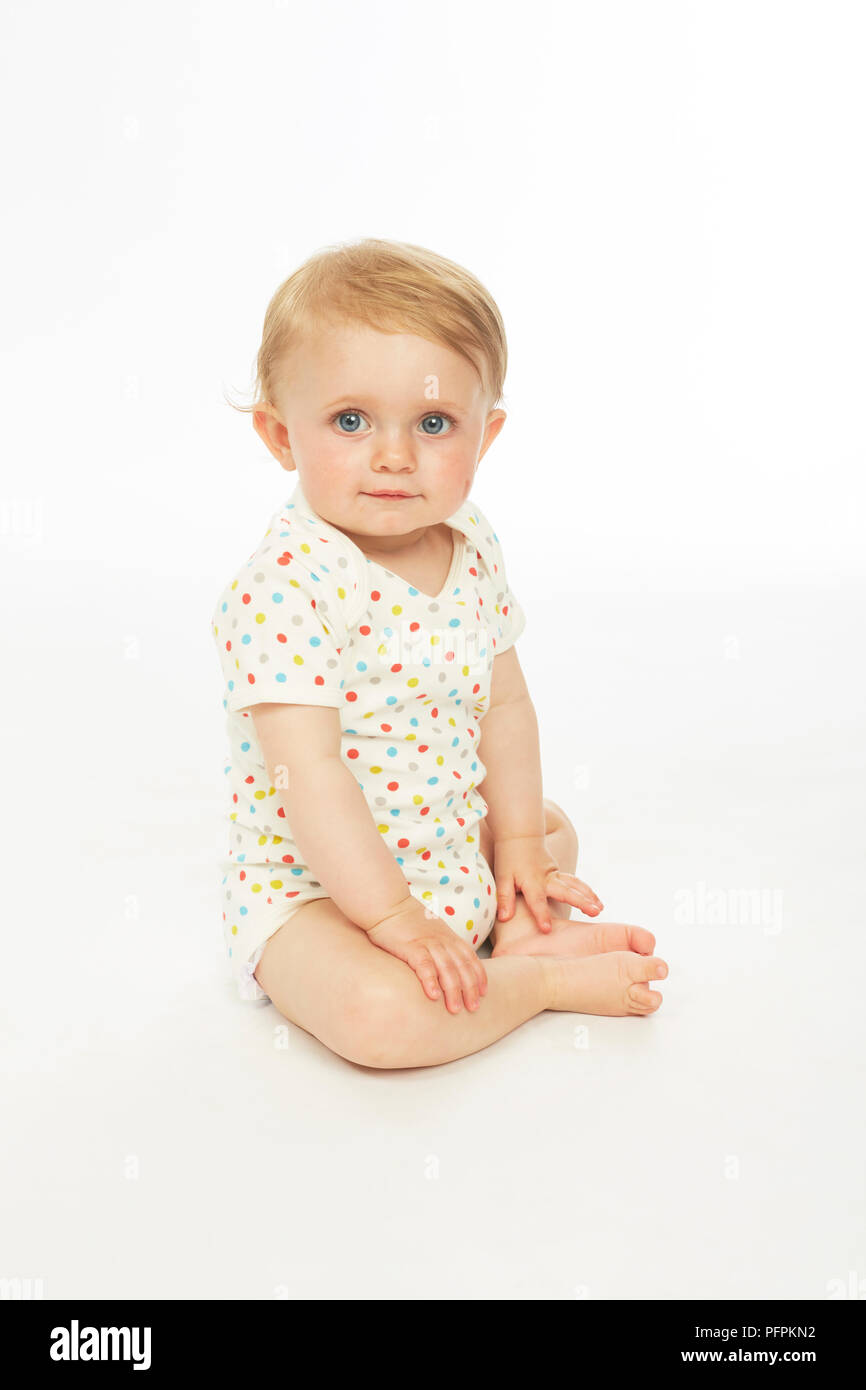 Bébé en monokini assis (modèle age - 9 mois) Banque D'Images