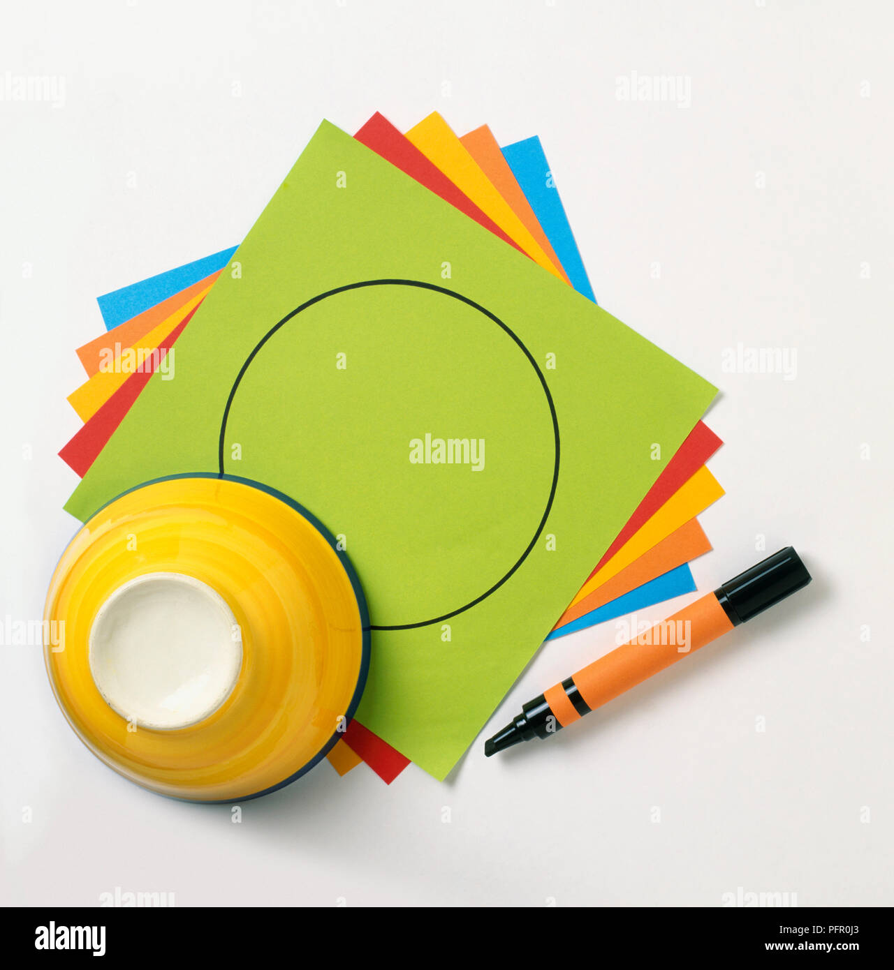 Feuilles de papier de couleur, la feuille supérieure avec cercle noir dessiné dessus à l'aide d'un bol à l'envers et stylo-feutre Banque D'Images