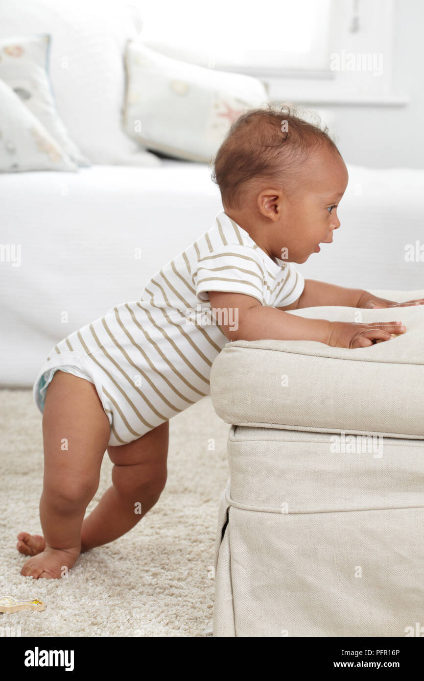 Bebe Garcon 8 Mois Debout Avec Ses Mains Sur Un Fauteuil Photo Stock Alamy