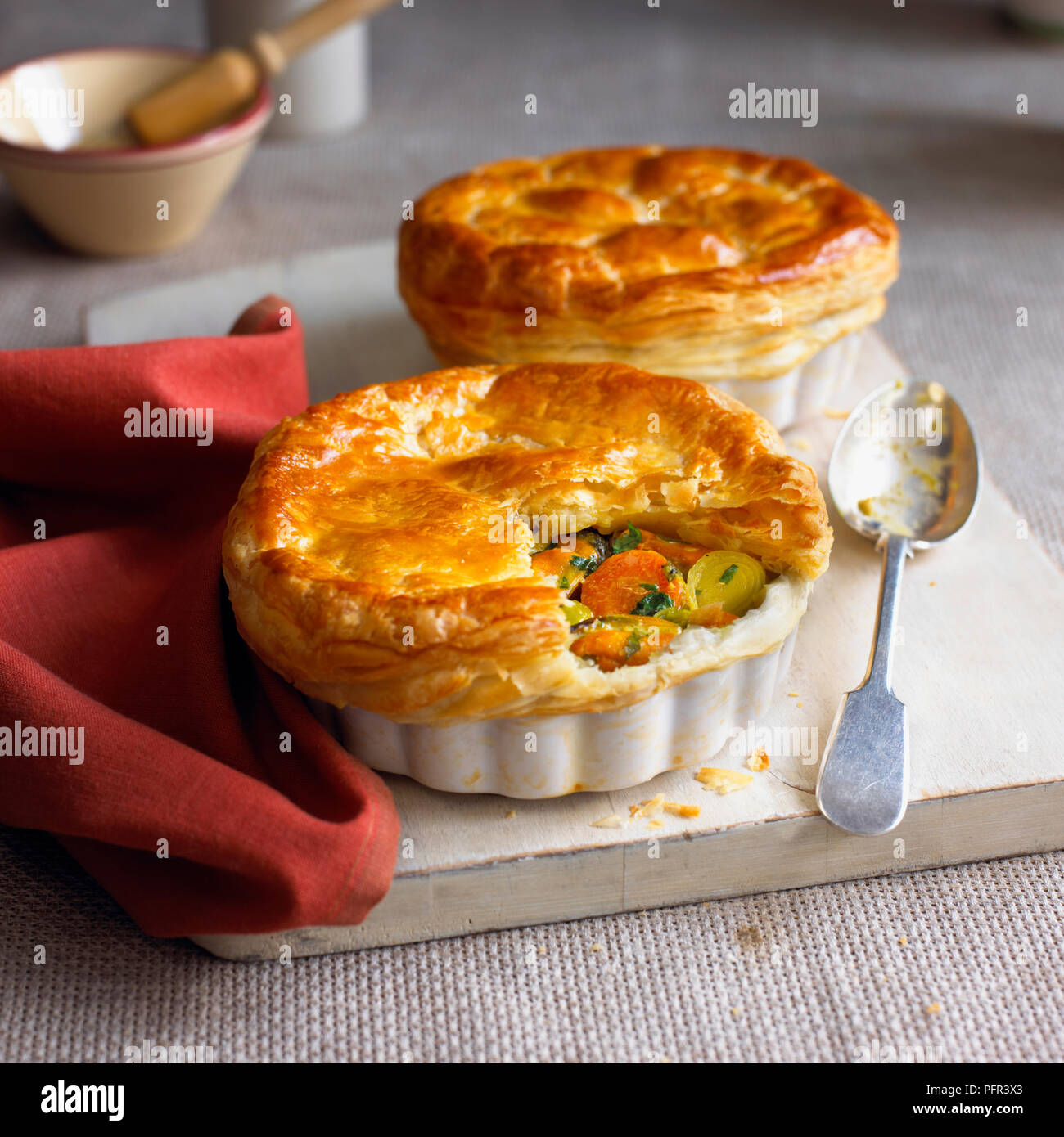 Moules au curry gâteau à la partie de la croûte enlevée montrant le remplissage, une autre tarte dans l'arrière-plan Banque D'Images