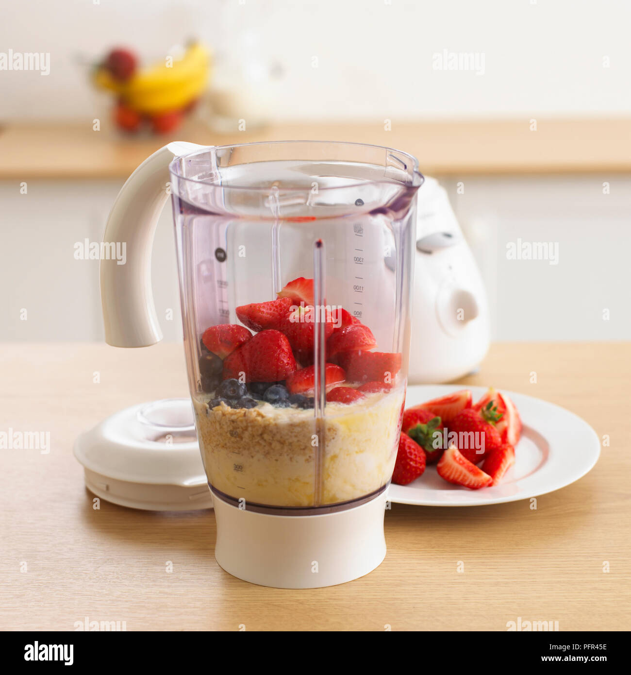 Bouillie d'avoine, lait, les bleuets et les fraises dans un blender Banque D'Images