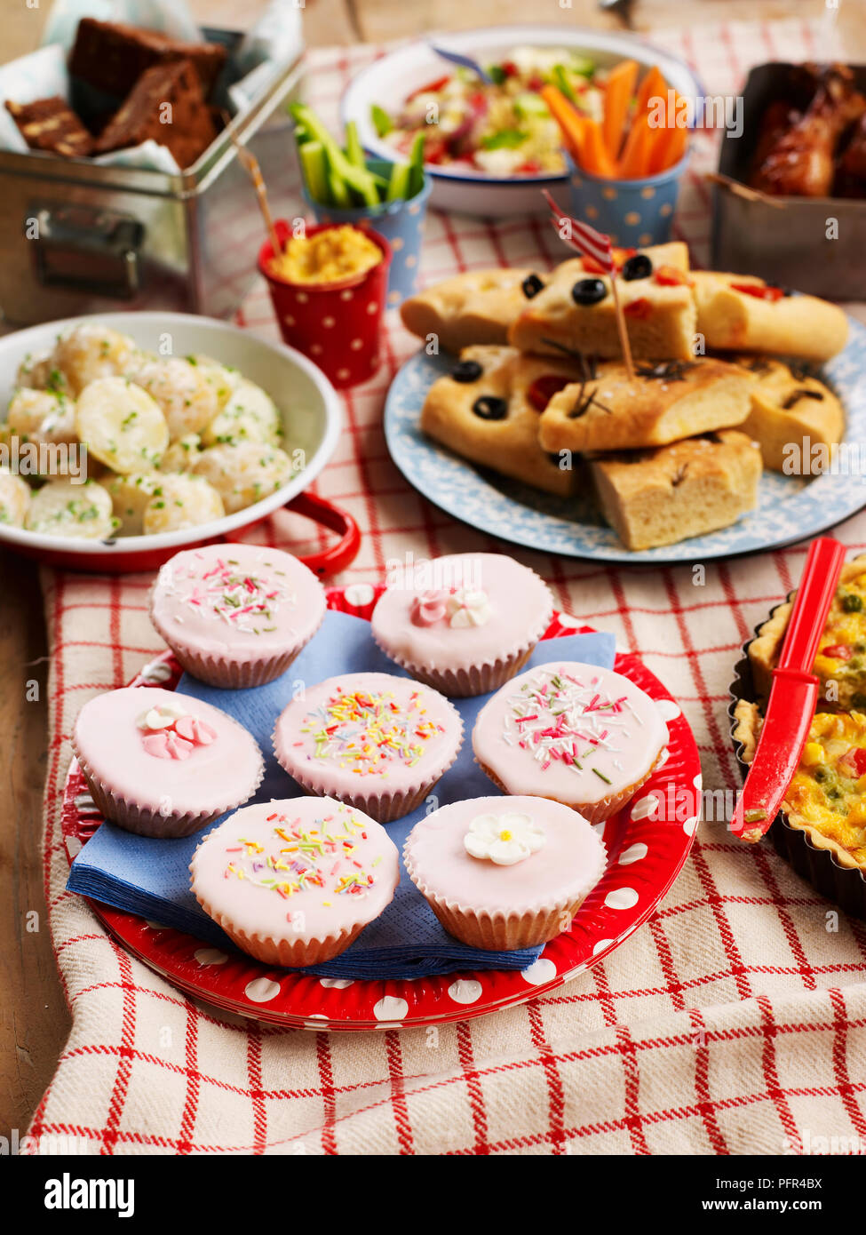 Sélection de plats sucrés et salés, cupcakes, salade de pommes de terre, pain focaccia, disposés sur table, cuisine de fête Banque D'Images