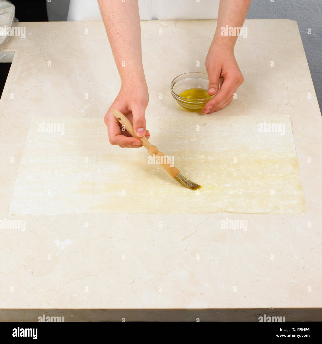 Faire une pastilla, colis pâtisserie au brossage de la première feuille de pâte filo avec l'huile Banque D'Images