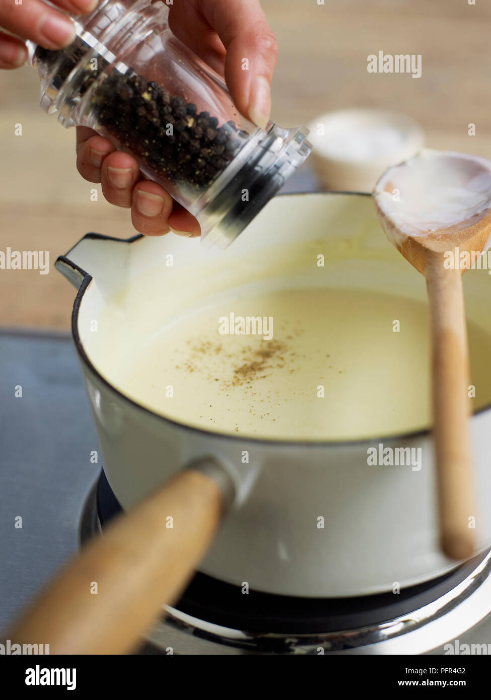 L'ajout de poivre sauce béchamel Banque D'Images
