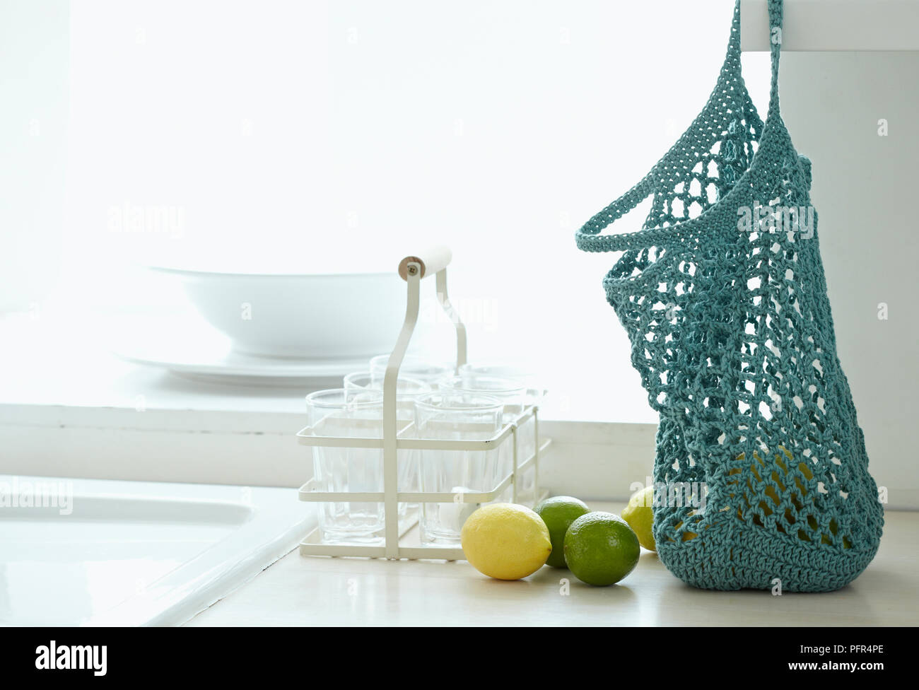 Chaîne au crochet sac sur le plan de travail de cuisine de citrons et limes Banque D'Images