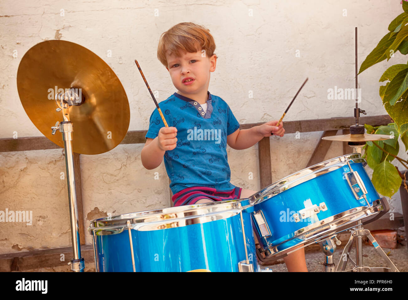 3 an amazing Kid Drummer jouant avec une attitude rockstar Banque D'Images