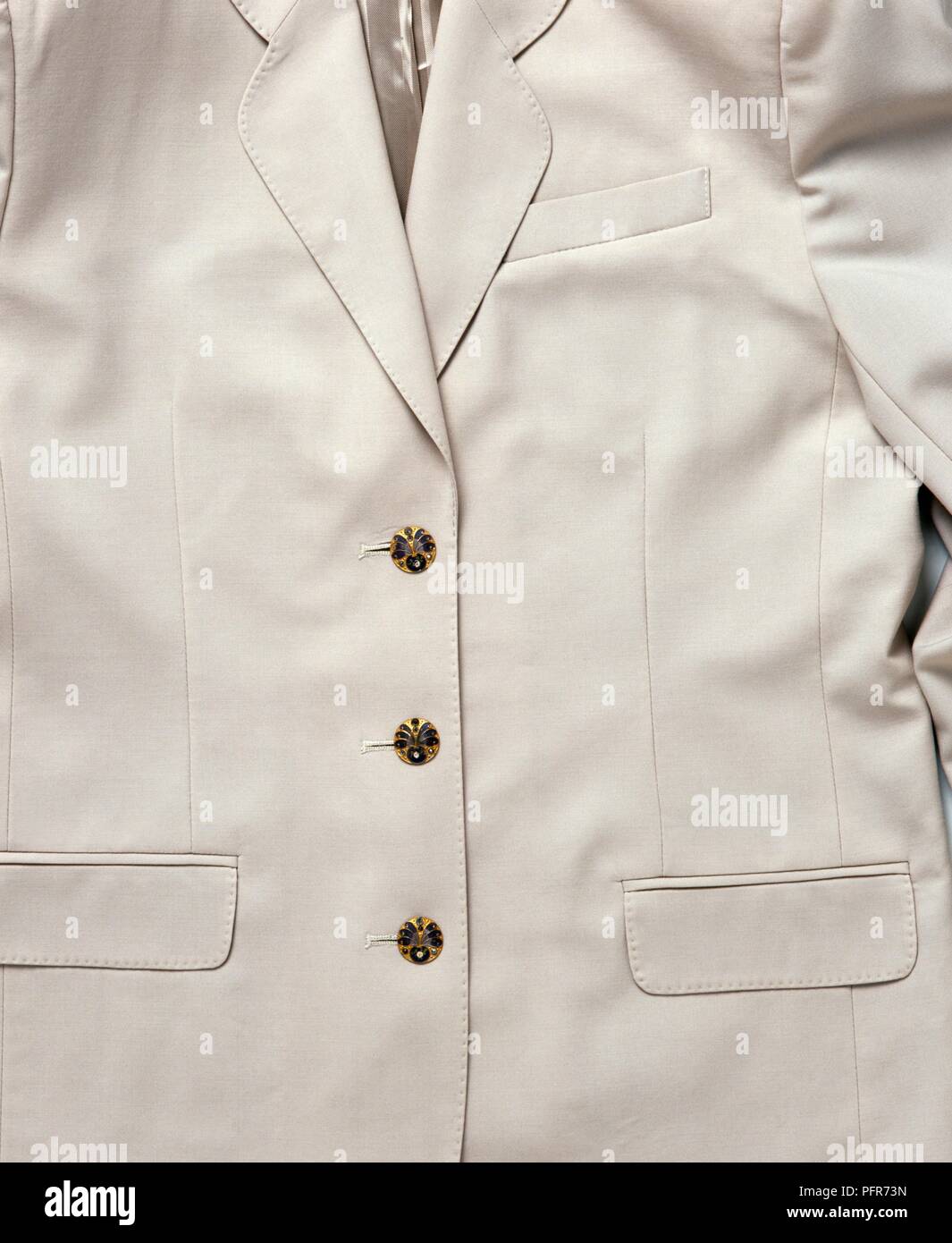 Boutons en métal émaillé et en relief sur un blazer blanc, close-up Banque D'Images
